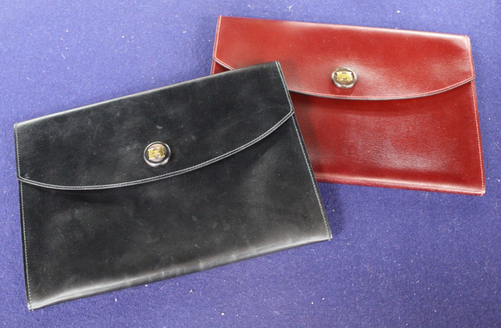 Two Hermes leather clutch purses, one in black, the other burgundy, 24 x 16.5cm, with one Hermes orange card box